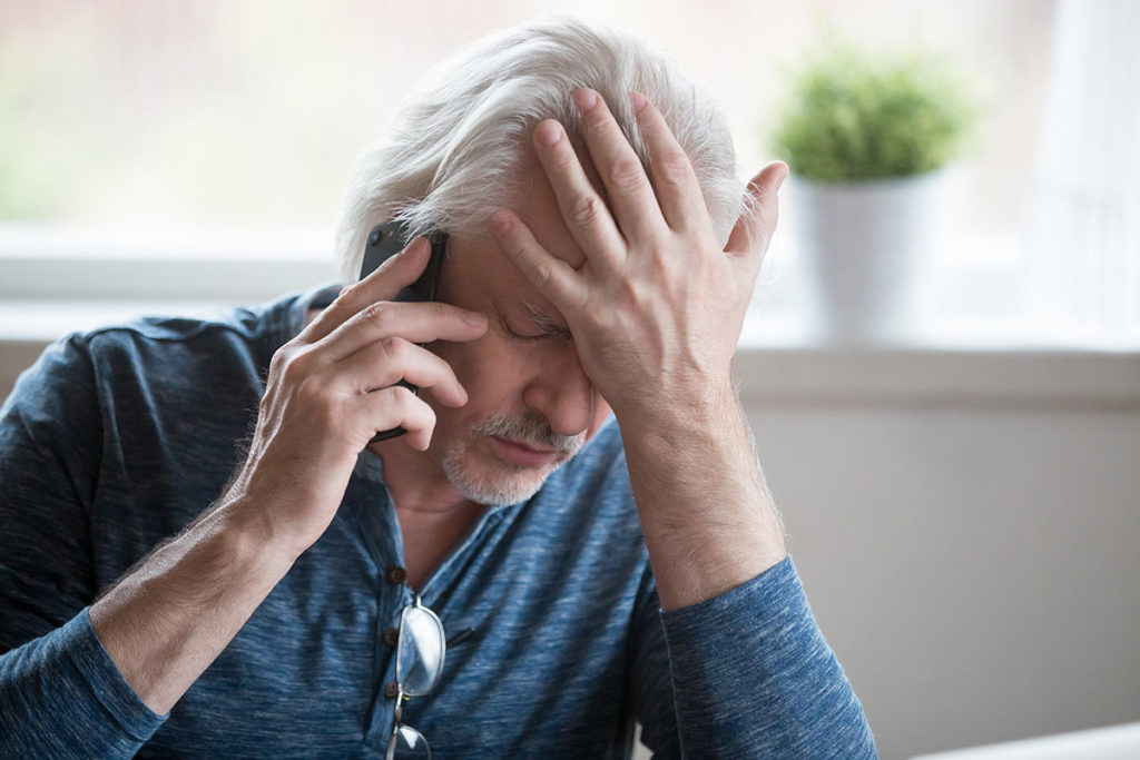 man on phone experiencing anguish